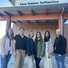 Six smiling teacher candidates standing in front of school